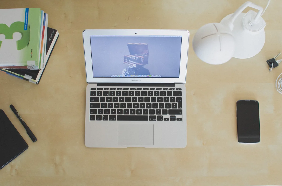 A laptop, a phone and a notebook on a desk — the demo object